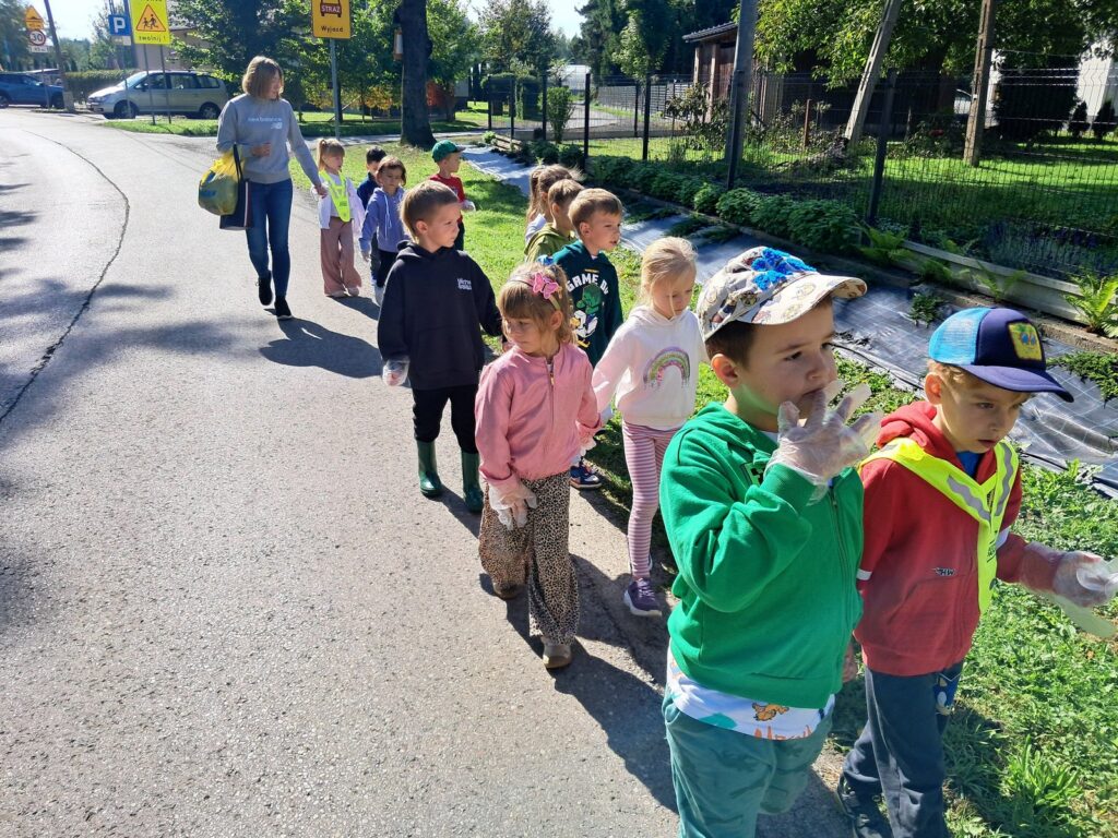 dzieci sprzątające teren wokół przedszkola